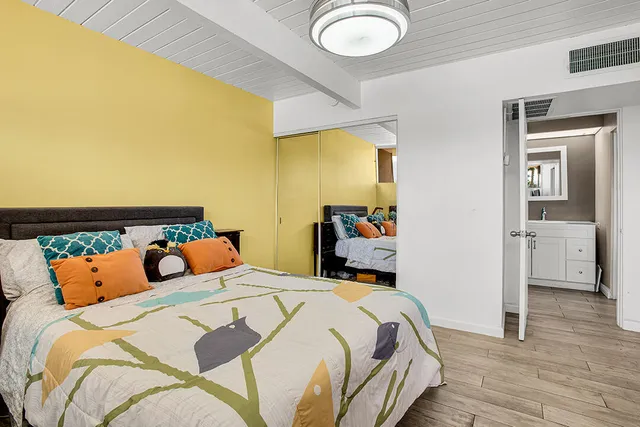 a bedroom with bed and wooden floor