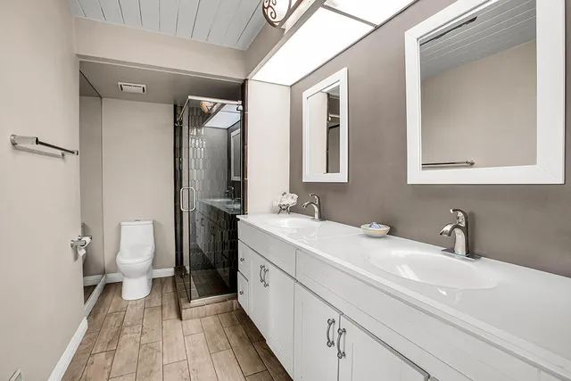 a bathroom with a sink a toilet and a mirror