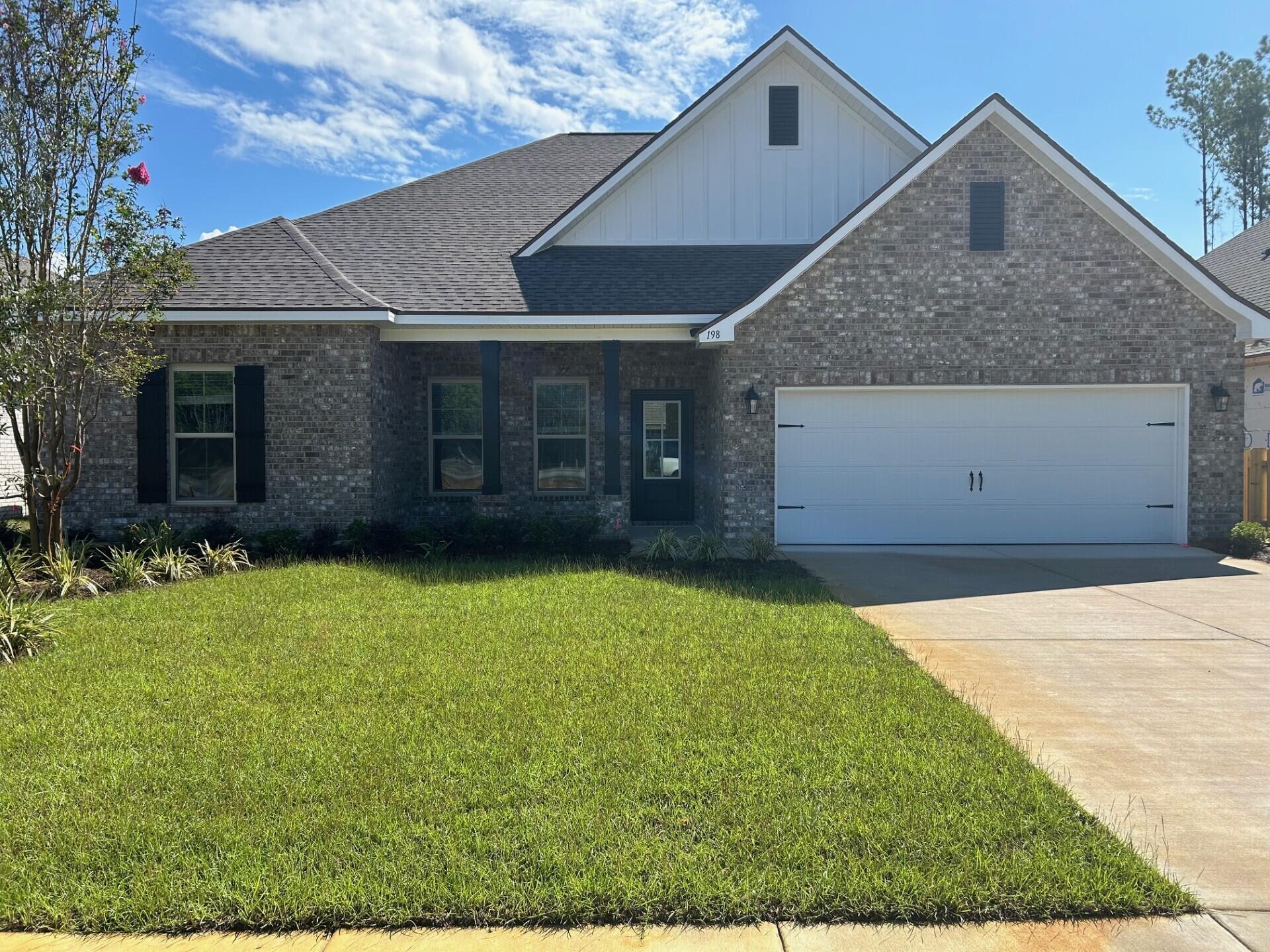 198 Lumen Loop Freeport, FL 32439 - Photo 1 of 3 a front view of a house with a garden