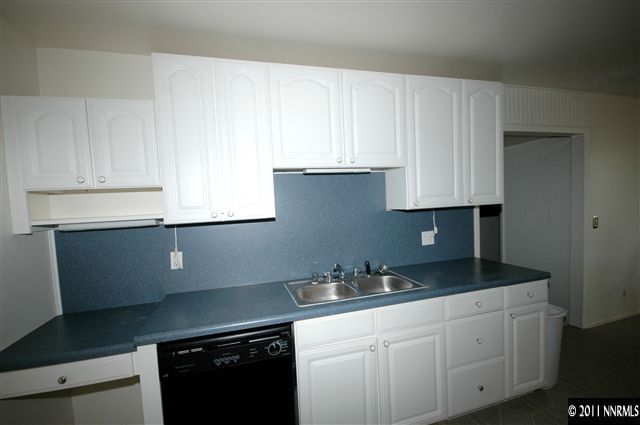 3630 West 7th Street Reno, NV 89503 - Photo 2 of 7 a kitchen with granite countertop white cabinets and a sink