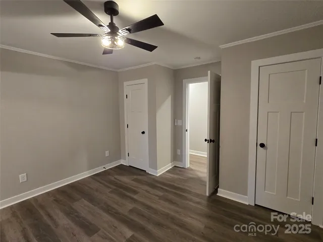 an empty room with wooden floor and ceiling fan