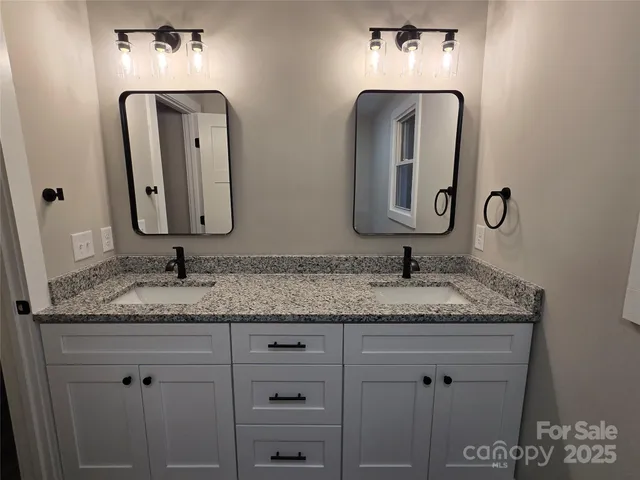 a bathroom with double vanity sinks and a mirror