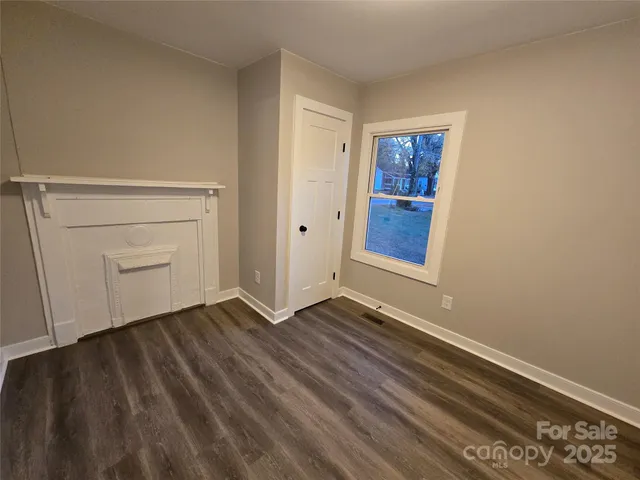 a view of an empty room with closet and a window