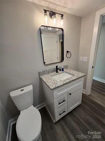a bathroom with a granite countertop toilet sink and mirror
