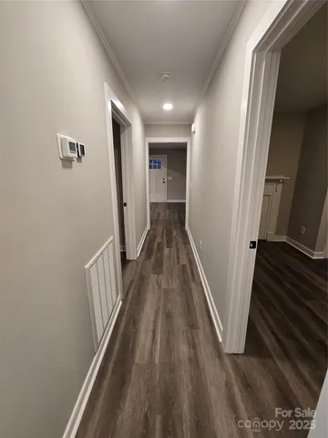 a view of a hallway with wooden floor and staircase