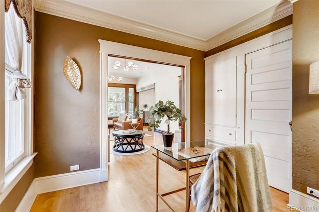 a dining room with chandelier and wooden floor