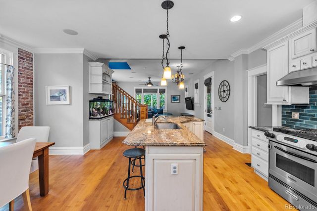 a kitchen with stainless steel appliances granite countertop a stove a sink and a refrigerator