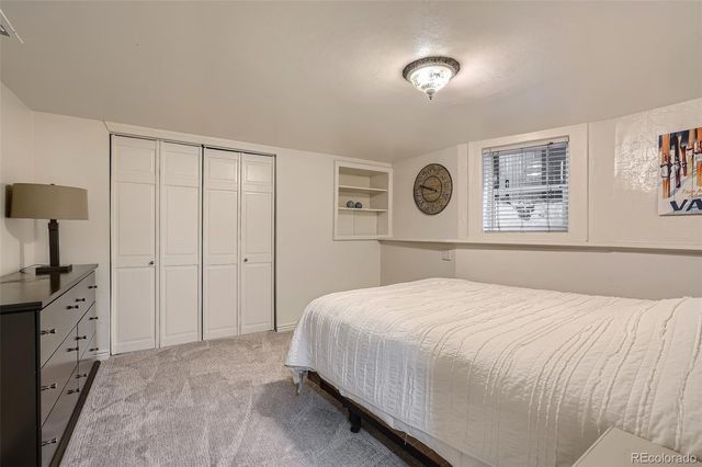 a large white bed in a white room with a mirror