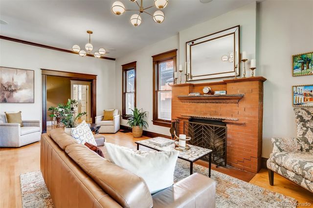 a living room with furniture a chandelier and a fireplace