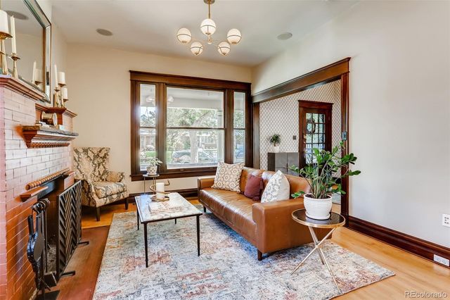 a living room with fireplace furniture and a large window