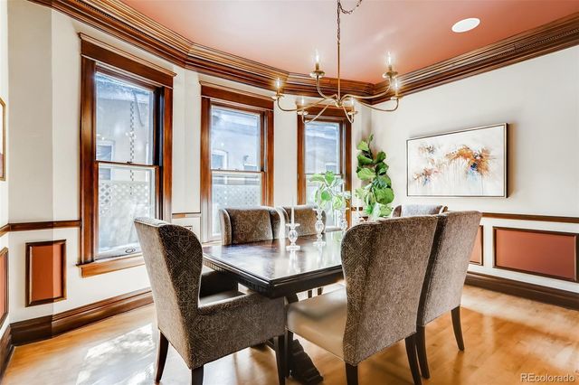 a dining room with furniture a chandelier and wooden floor