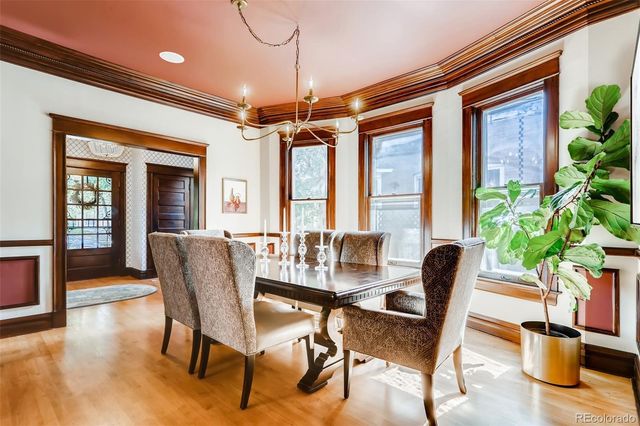 a dining room with furniture potted plants and wooden floor