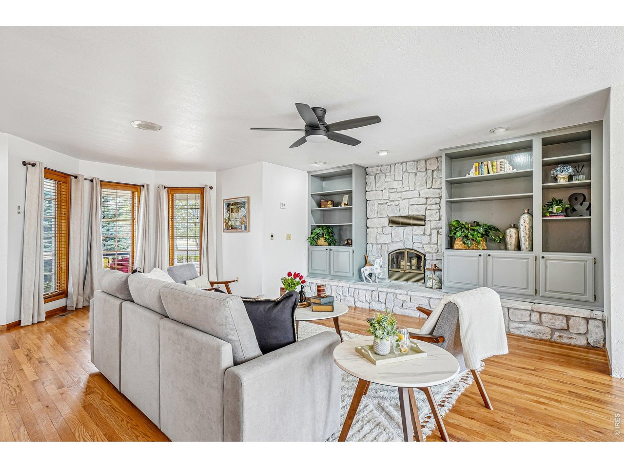 Custom built cabinets and stone wood-burning fireplace adds character to the living room
