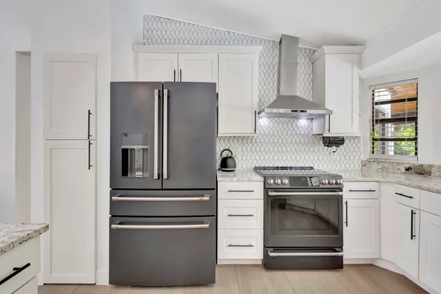 a living room with furniture a dining table wooden floor and a chandelier