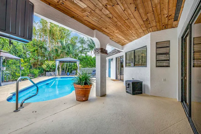 a view of swimming pool with chairs and table under an umbrella
