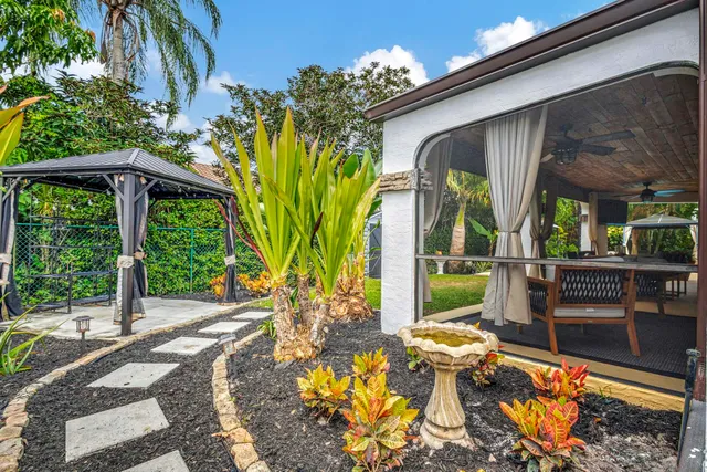 a front view of a house with a garden and plants