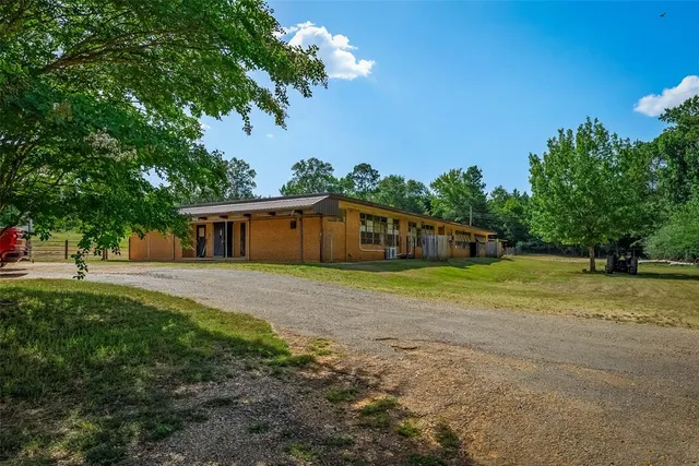 a front view of a house with a yard and trees