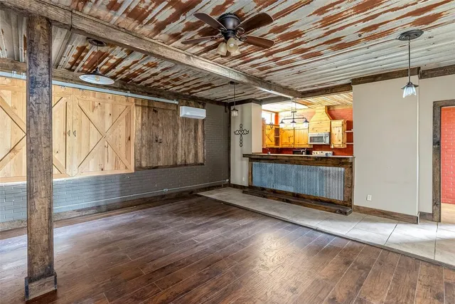 a view of an empty room with wooden floor and windows