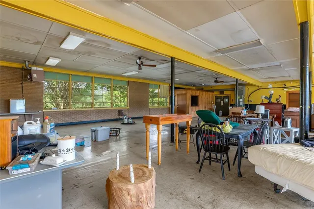 a living room with furniture a flat screen tv and a large window