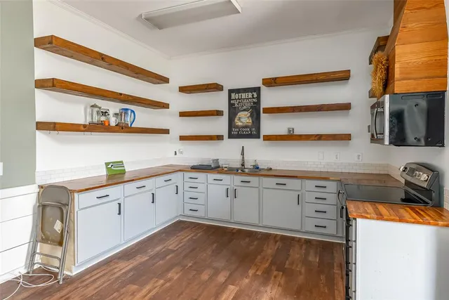 a kitchen with granite countertop cabinets sink and a stove