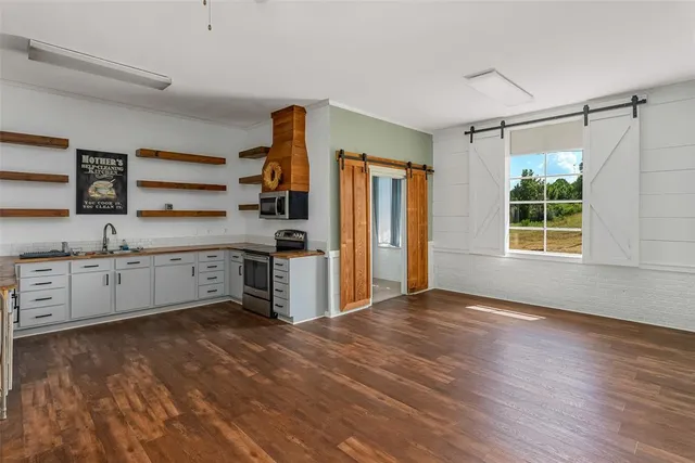 a kitchen with stainless steel appliances a sink cabinets and wooden floor