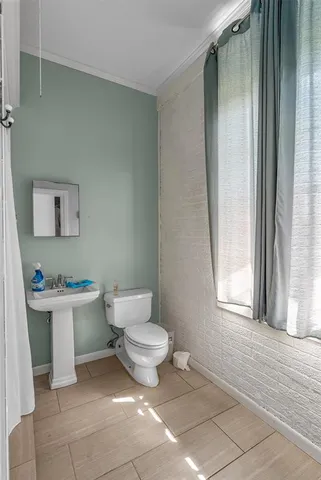 a bathroom with a toilet a sink and a window