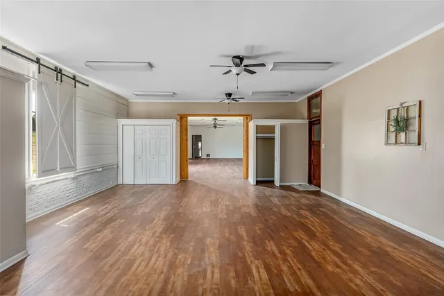 a view of empty room with wooden floor and ceiling fan