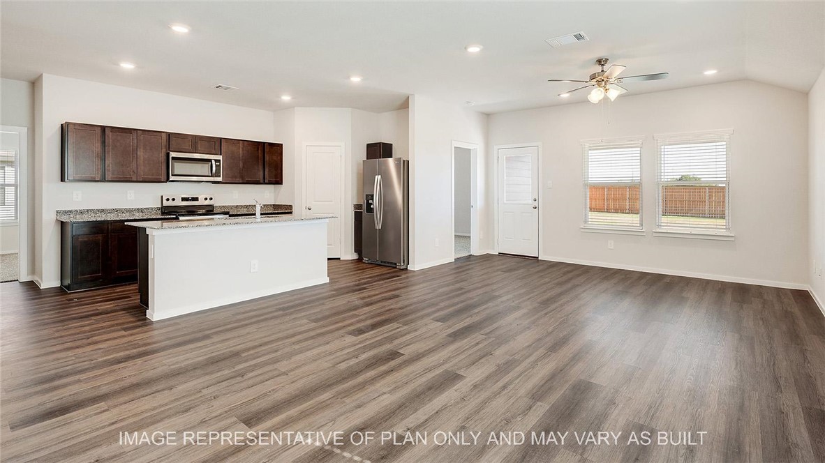 5539 Harriet Street Bryan, TX 77807 - Photo 5 of 17 an empty room with wooden floor and kitchen view