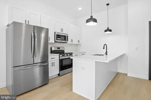 a kitchen with a refrigerator a sink and cabinets