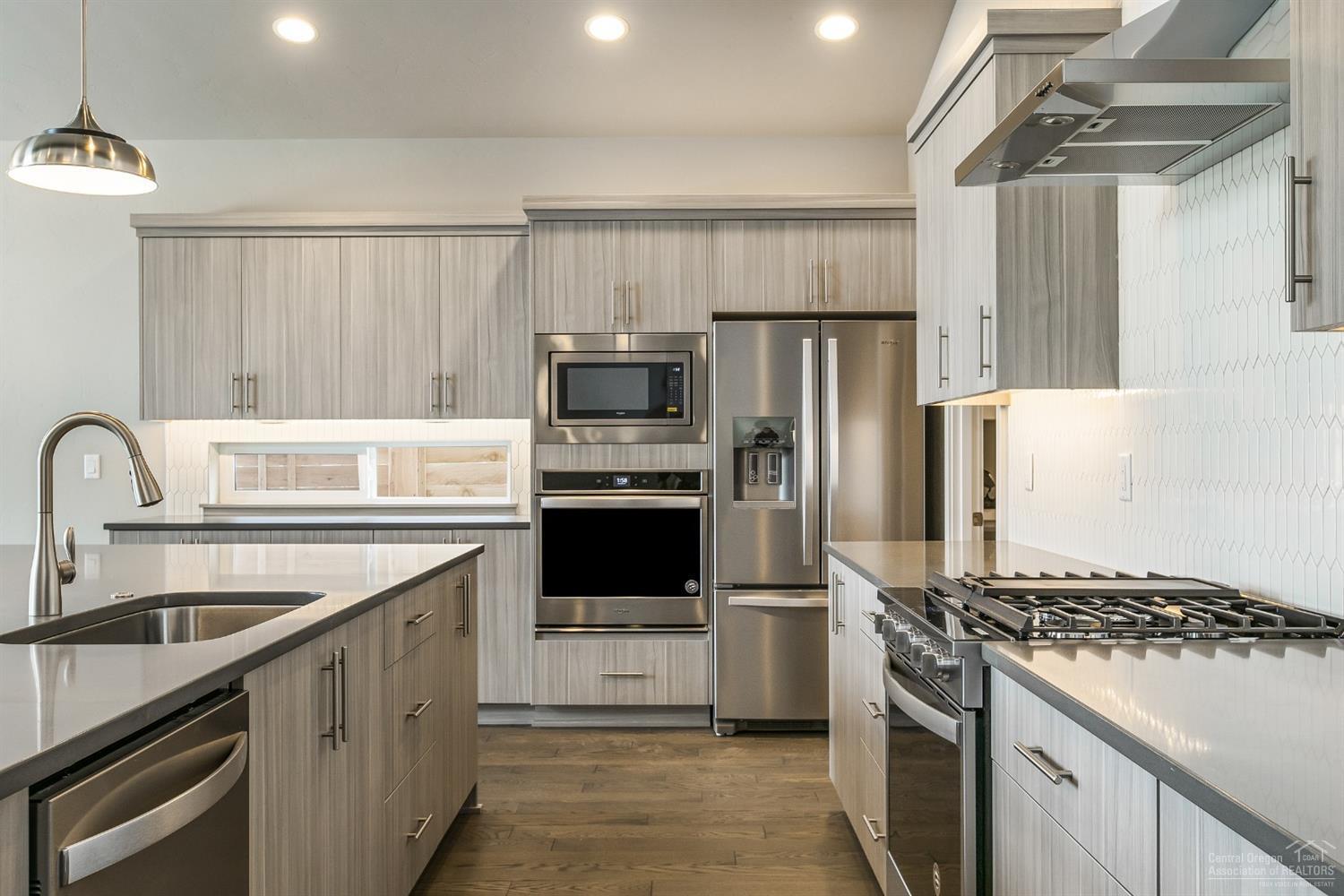 63120 Iner Loop Bend, OR 97701 - Photo 8 of 25 Gas Stove top with ceiling height back splash and stainless hood. Pictures are of a similar home.