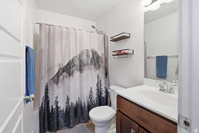 1024 South 270 West Logan, UT 84321 - Photo 25 of 37 Bathroom featuring vanity, a shower with curtain, and a textured ceiling