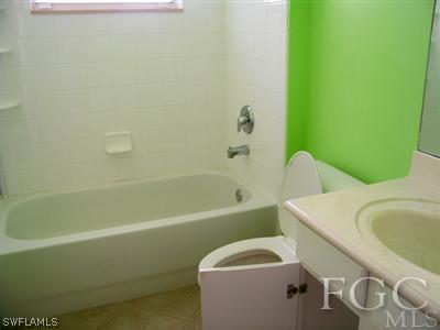 9329 Chestnut Tree Loop, Unit Q Fort Myers, FL 33967 - Photo 6 of 8 a bathroom with a sink a toilet and bathtub