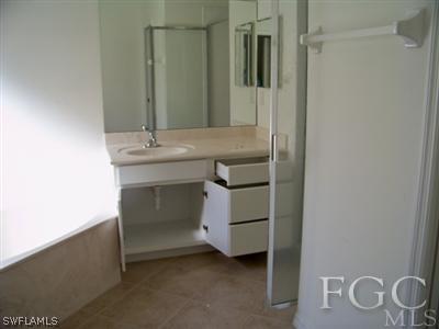 9329 Chestnut Tree Loop, Unit Q Fort Myers, FL 33967 - Photo 8 of 8 a bathroom with a sink and a mirror