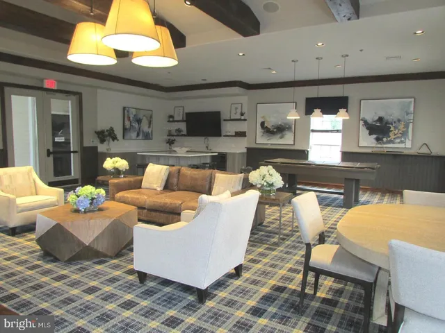 a living room with furniture a flat screen tv and kitchen view