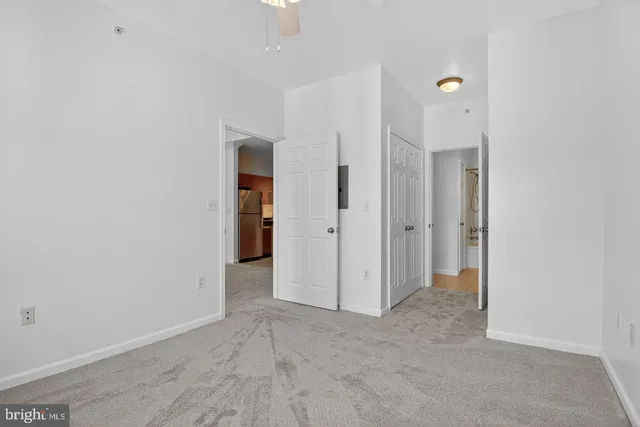 an empty room with closet and a hallway