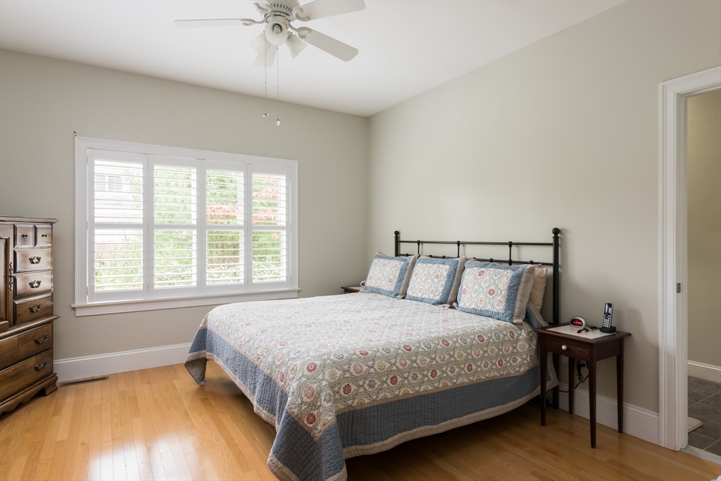 9 Hathaway Pond Circle, Unit 9 Rochester, MA 02770 - Photo 17 of 38 a bedroom with a bed and a chandelier