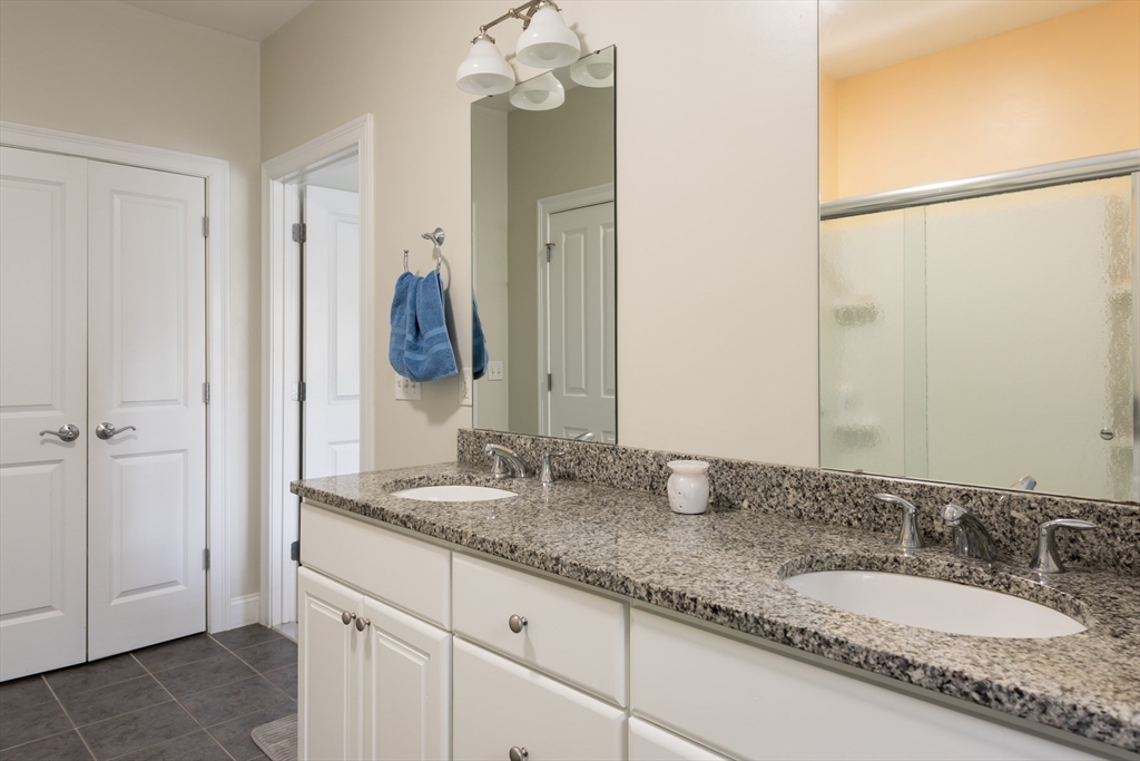 9 Hathaway Pond Circle, Unit 9 Rochester, MA 02770 - Photo 19 of 38 a bathroom with a granite countertop double vanity sink and a mirror