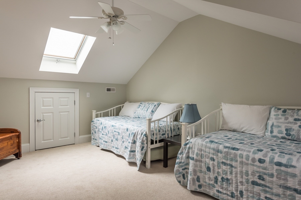 9 Hathaway Pond Circle, Unit 9 Rochester, MA 02770 - Photo 25 of 38 a bedroom with a bed and a chandelier