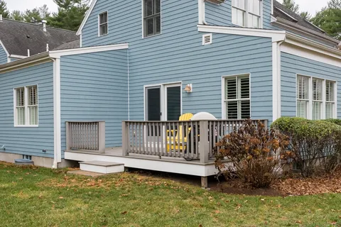 a view of a house with a small deck and a yard