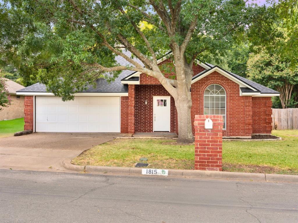 a front view of a house with a garden and yard