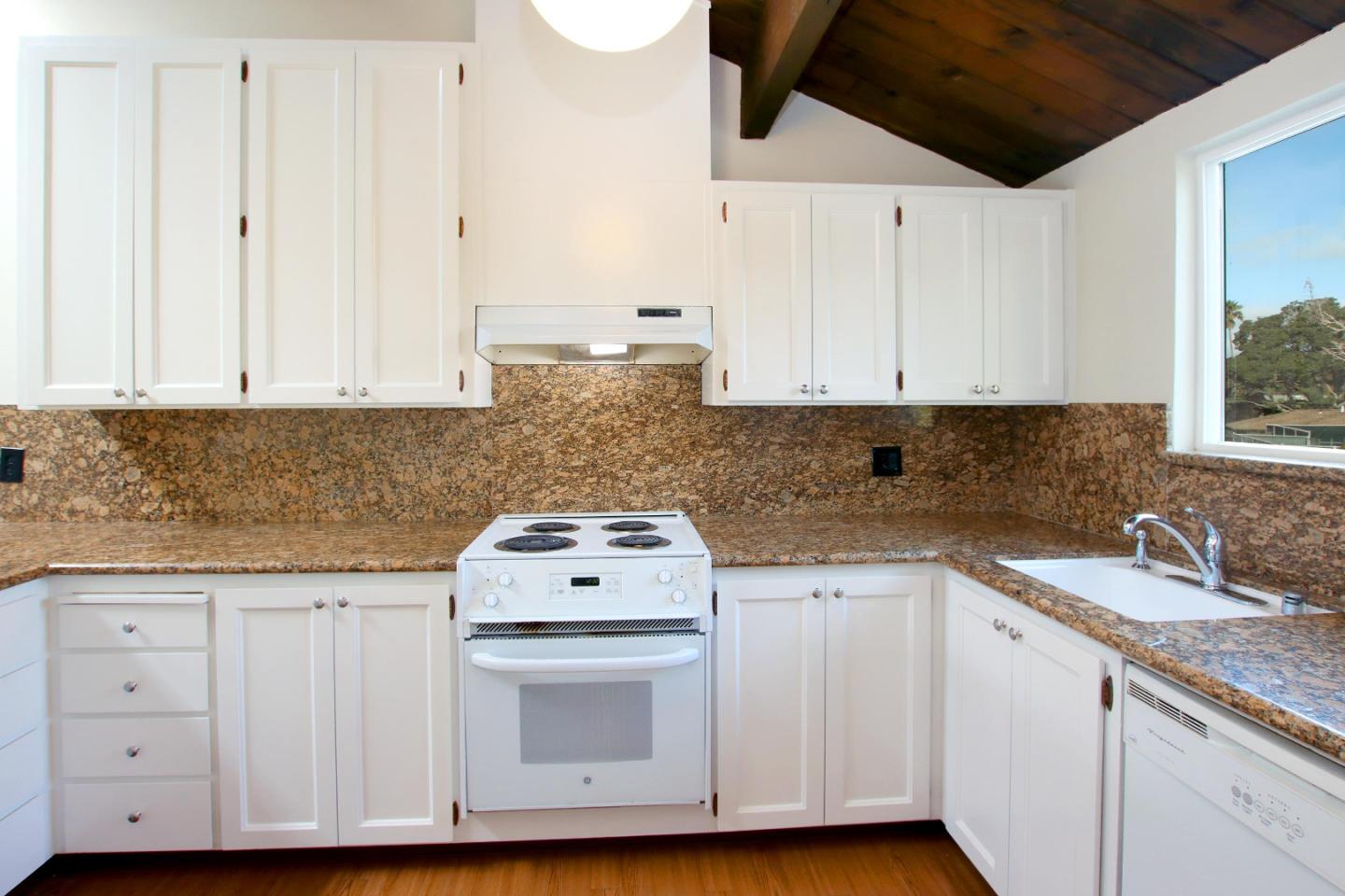 103 Shelter Lagoon Drive Santa Cruz, CA 95060 - Photo 5 of 39 a kitchen with granite countertop white cabinets and white appliances