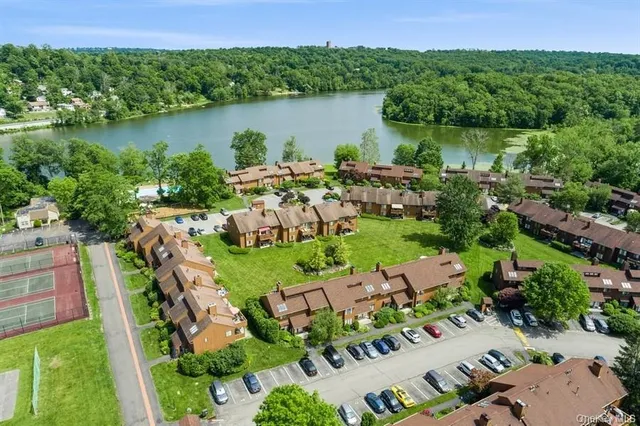 an aerial view of lake residential house with outdoor space and trees around
