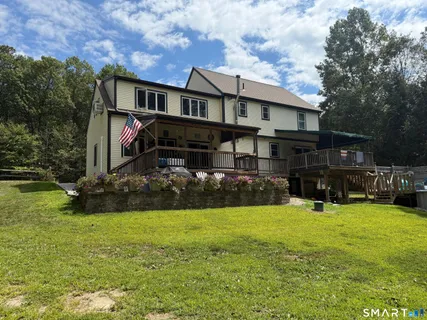 a view of a house with a big yard and large trees