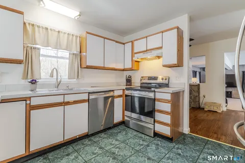 a kitchen with stainless steel appliances granite countertop a sink stove and cabinets