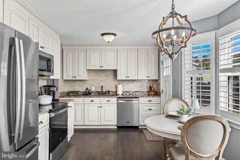 a kitchen with a refrigerator a stove a sink and cabinets