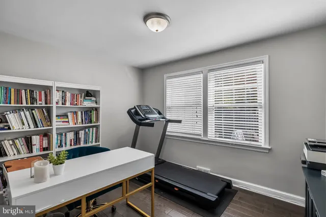 a view of a workspace with furniture and a bookshelf