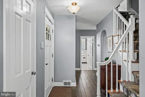 a view of a hallway with wooden floor and staircase