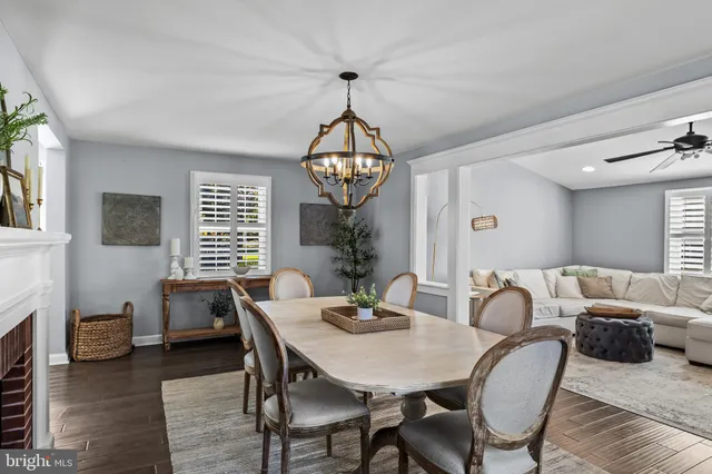a dining room with furniture a chandelier and wooden floor