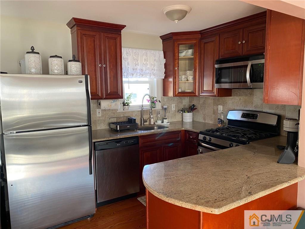 200 New Dover Road Colonia, NJ 07067 - Photo 2 of 14 a kitchen with stainless steel appliances granite countertop a sink stove and refrigerator