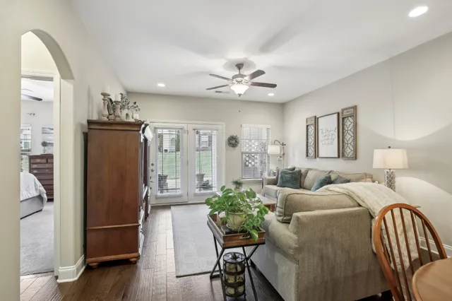 a living room with furniture a large window and wooden floor